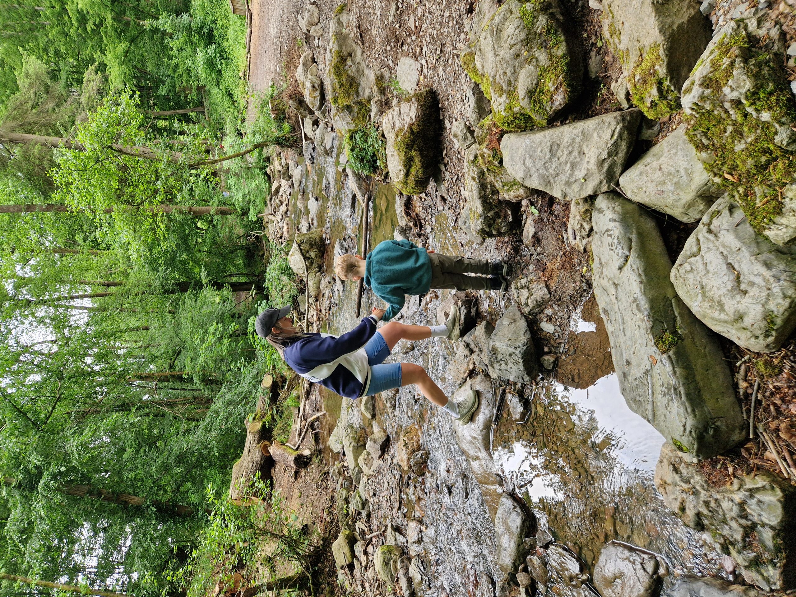 Ninglinspo hike met kinderen - moeder en kind steken rivier over en houden hand vast